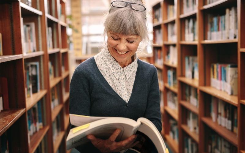 a woman reading a book in a library