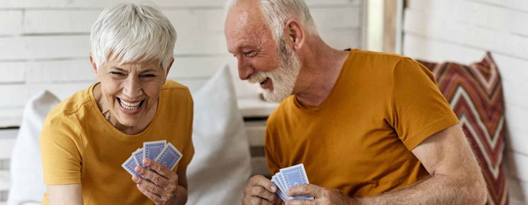 a man and woman sitting at a table playing cards